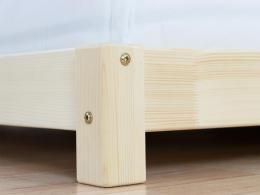 Nízká postel s detailem nohy